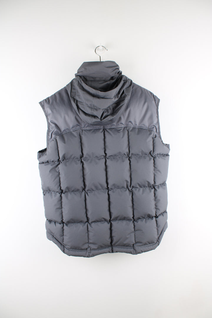 Vintage Nike padded gilet in grey, zip up, insulated, hidden hood, and has swoosh logo embroidered on the front. 