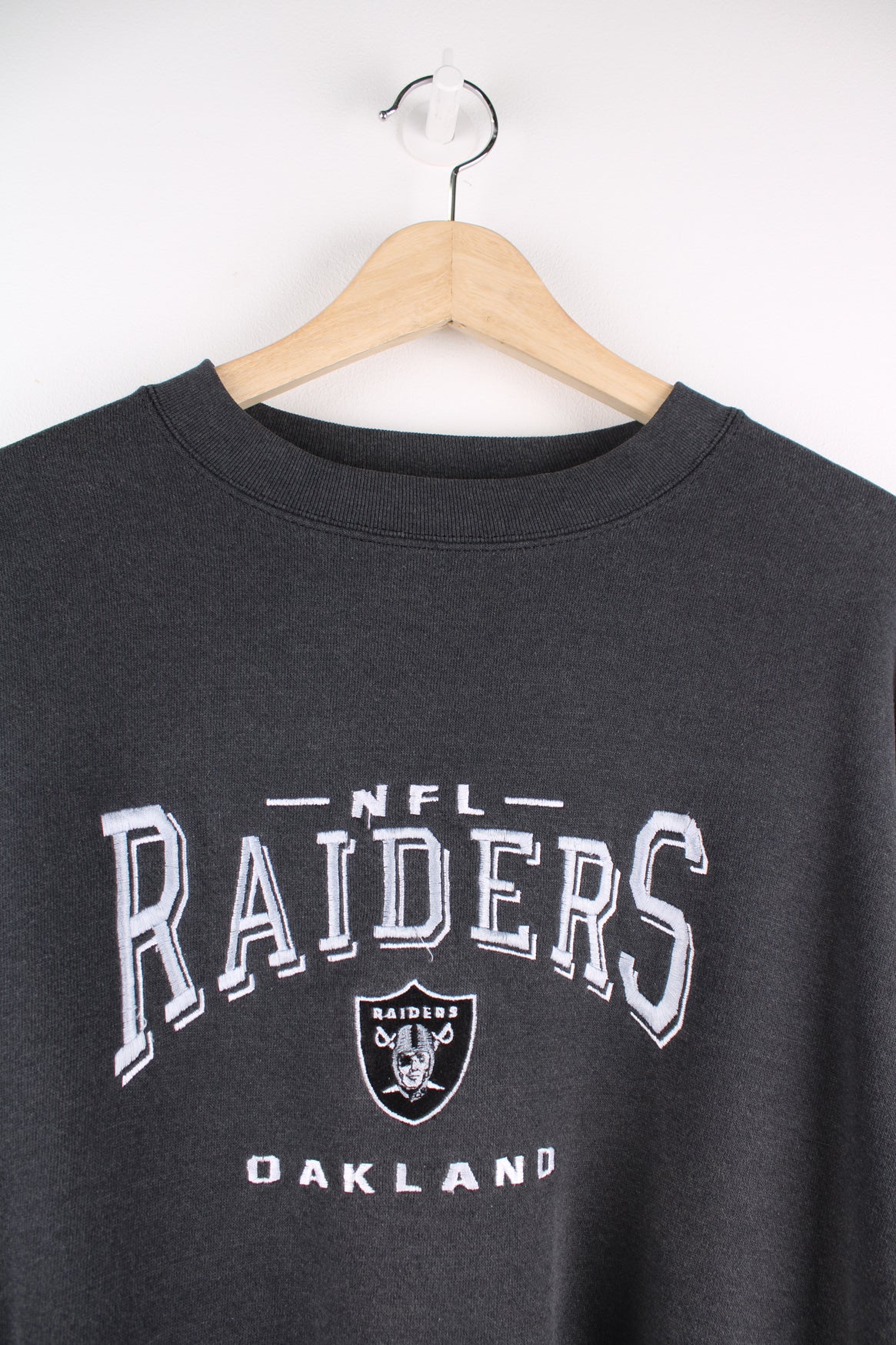 Oakland Raiders faded black sweatshirt by Lee Sport, features embroidered spell-out details on the front