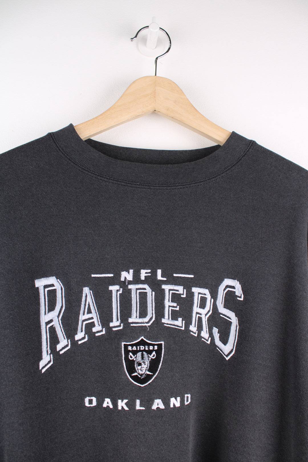 Oakland Raiders faded black sweatshirt by Lee Sport, features embroidered spell-out details on the front