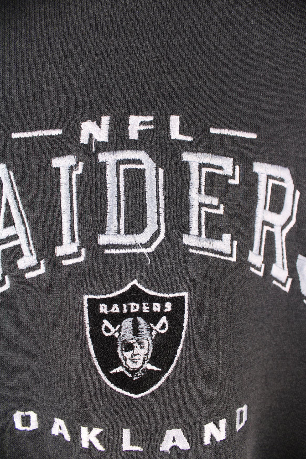 Oakland Raiders faded black sweatshirt by Lee Sport, features embroidered spell-out details on the front