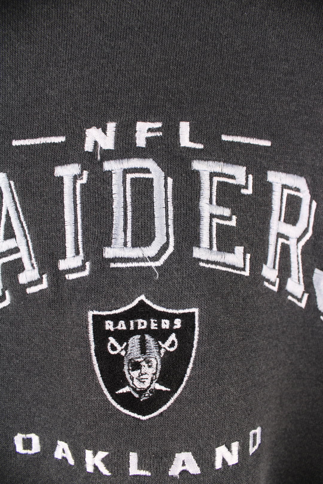 Oakland Raiders faded black sweatshirt by Lee Sport, features embroidered spell-out details on the front