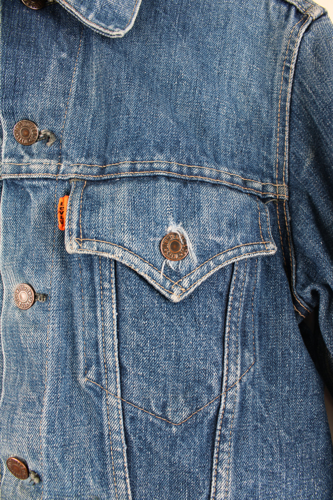 Vintage Levi's denim trucker jacket button up, double chest pockets, and has orange tab logo embroidered on the chest. 