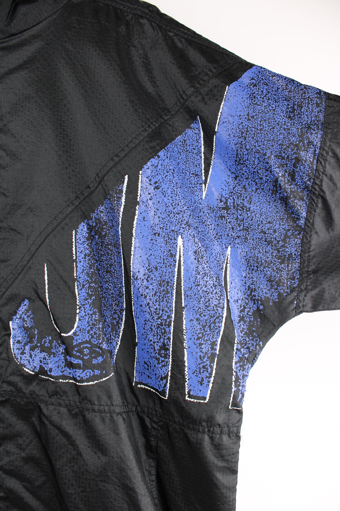 Umbro Windbreaker in a black and blue colourway, zip up, side pockets, and has the logo spell out printed across the front and back.