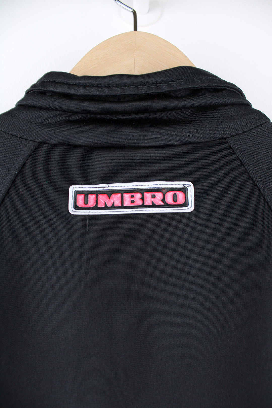 Umbro Tracksuit Jacket in a black, red and white colourway, zip up, side pockets, and has the logo embroidered on the front and back.