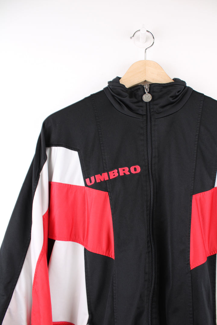 Umbro Tracksuit Jacket in a black, red and white colourway, zip up, side pockets, and has the logo embroidered on the front and back.