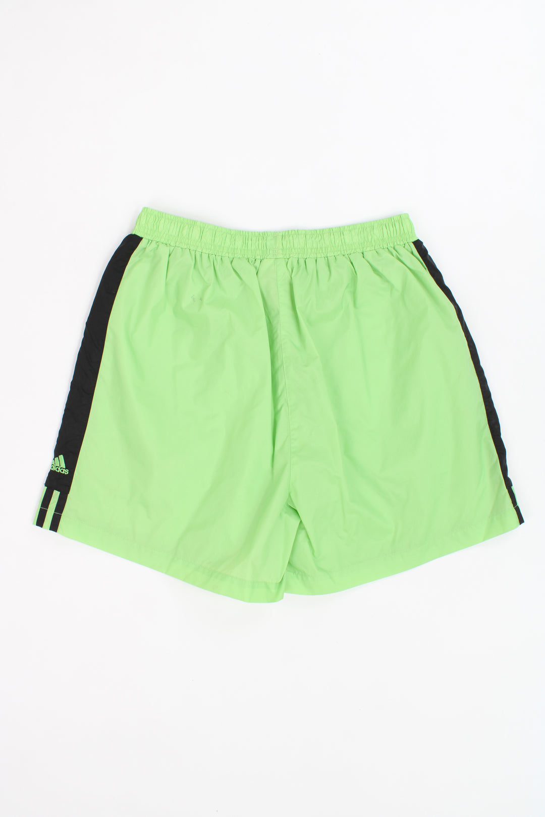 Vintage Adidas neon green nylon sport shorts with white three stripe details on the leg