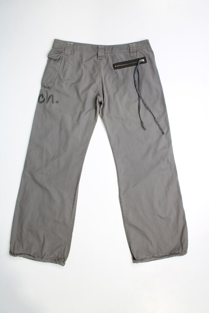 Y2k Bench low rise, grey, wide leg cargo trousers. Feature printed Bench logo on the leg and zips with long pulls on them.  good condition   Size in Label:  34 (XL)