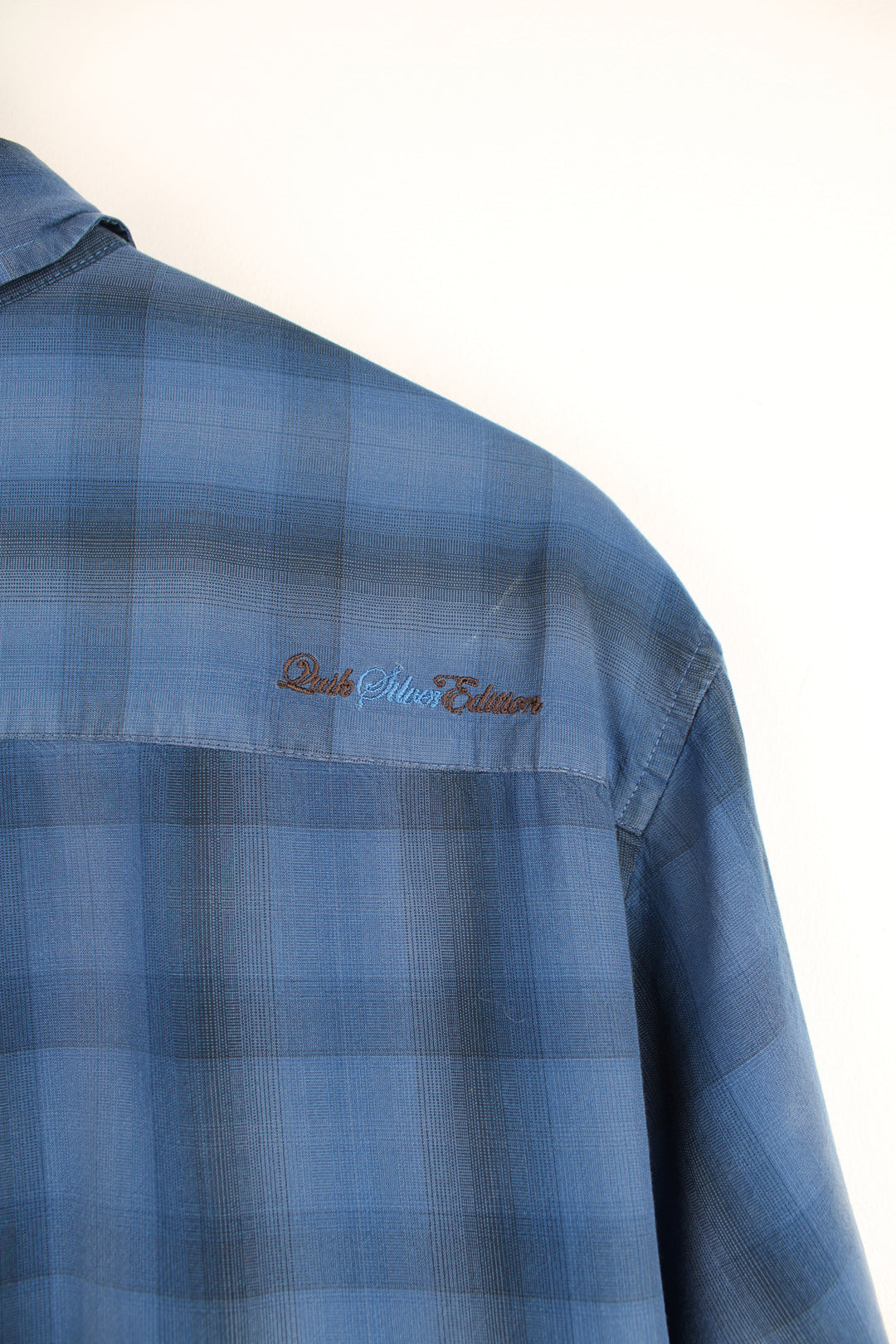 Quiksilver dark blue plaid button up shirt features chest pocket and embroidered logo on the back of the shoulder