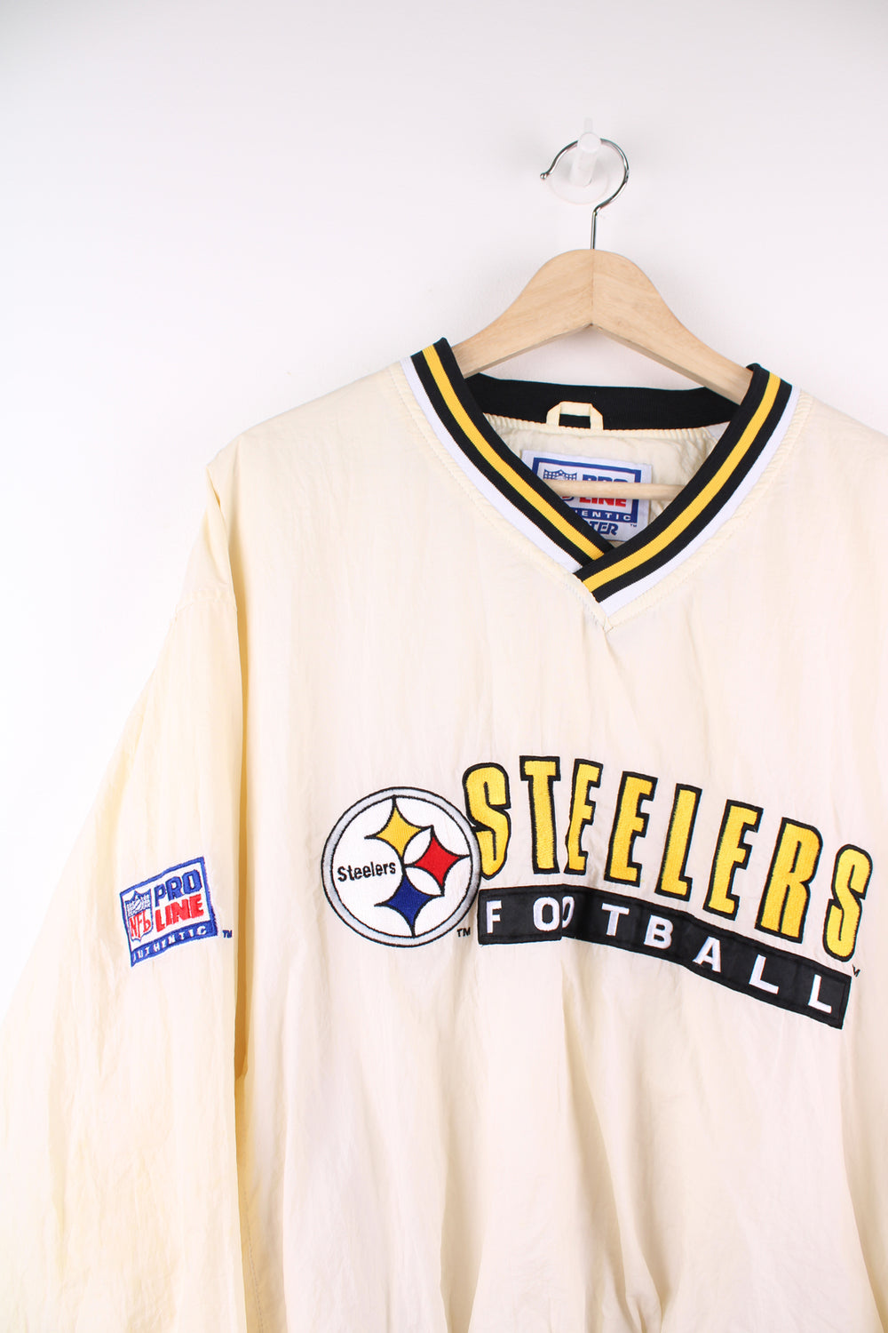 Vintage Pittsburg Steelers cream/off white nylon pullover training top by Starter with embroidered spell-out details across the chest and logo on the cuff