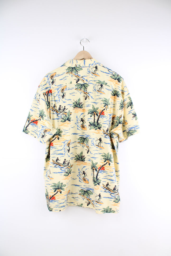 Gap Hawaiian Surfer Shirt in a yellow colourway, surfer and floral design printed all over, button up with a camp collar and has a chest pocket.