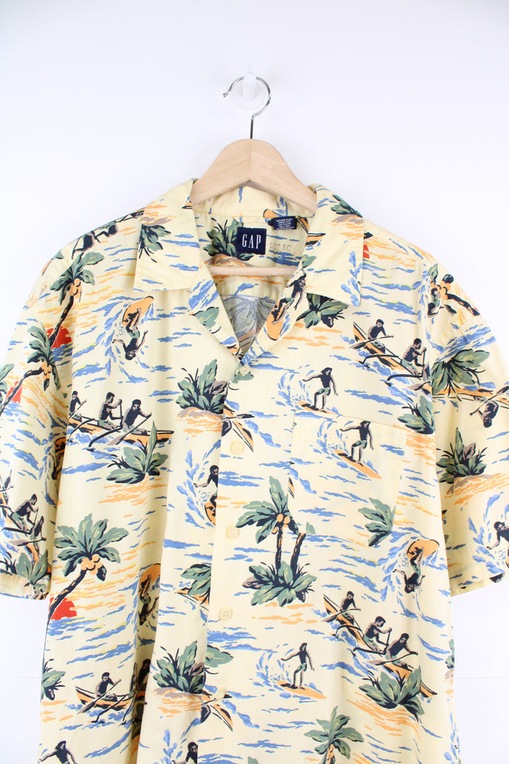 Gap Hawaiian Surfer Shirt in a yellow colourway, surfer and floral design printed all over, button up with a camp collar and has a chest pocket.