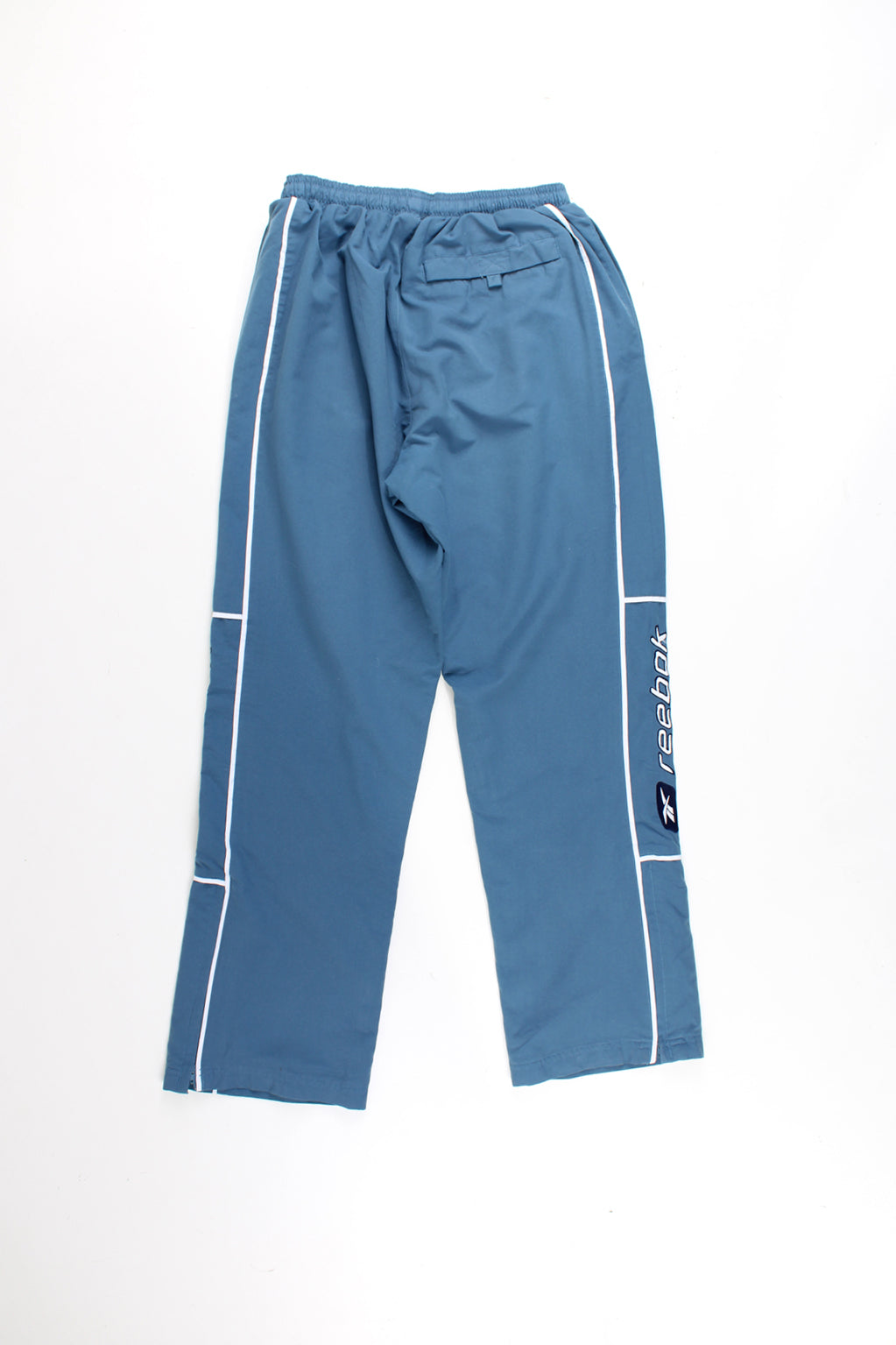 Reebok Tracksuit Bottoms in a blue colourway with white stipes and logo embroidered down the legs, and has a elasticated waist and pockets.