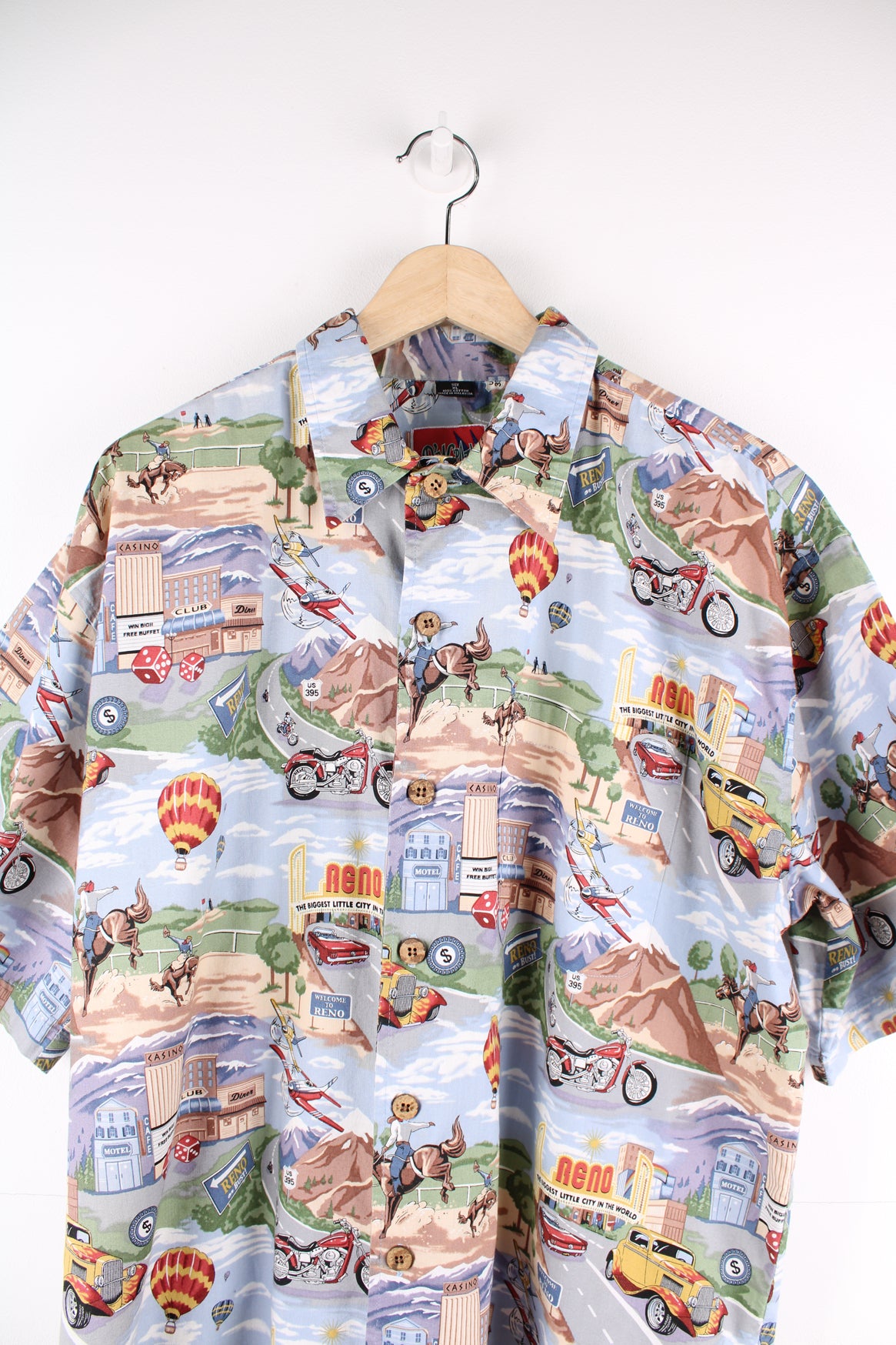 Vintage Dem Crazy Hawaiian Shirt in a blue colourway with gambling and rodeo style design printed all over, button up and has a chest pocket.