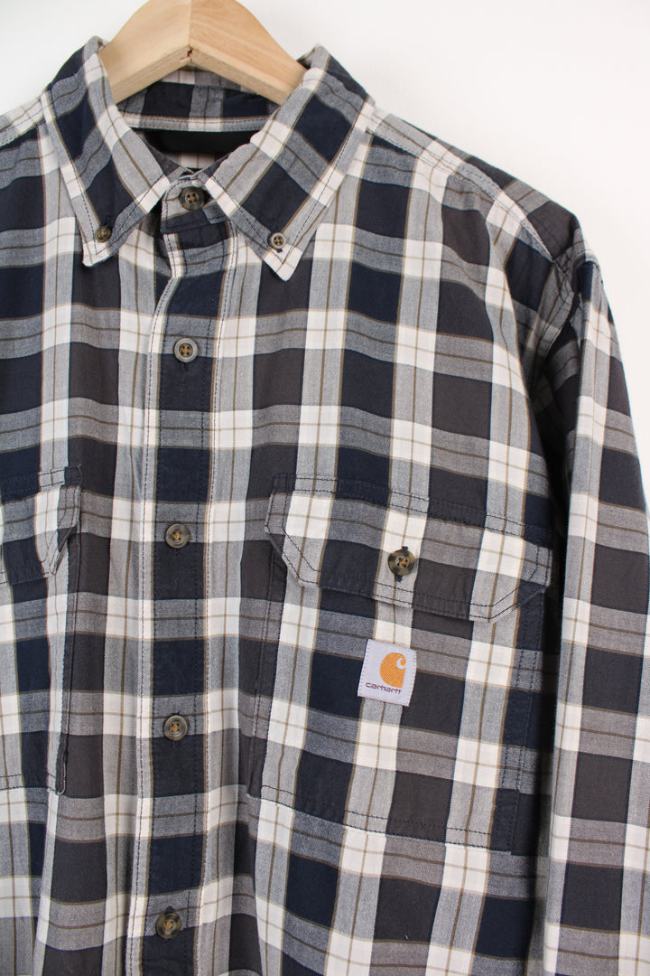 Navy blue plaid Carhartt loose fit, button up cotton shirt, has embroidered logo on chest pocket