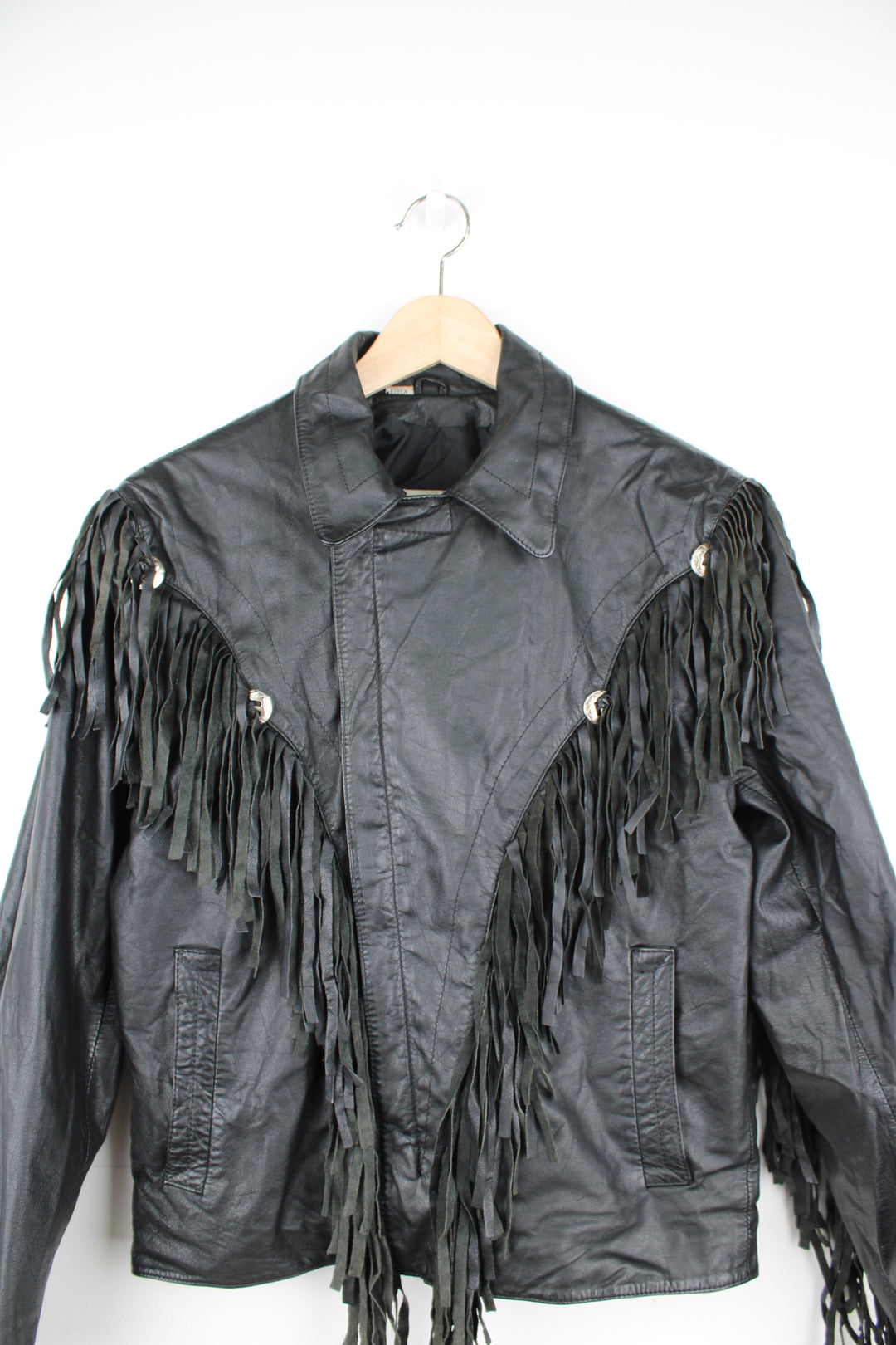 Vintage Wilson's black zip through leather jacket with fringe details on the back of the shoulders and silver conch buttons 