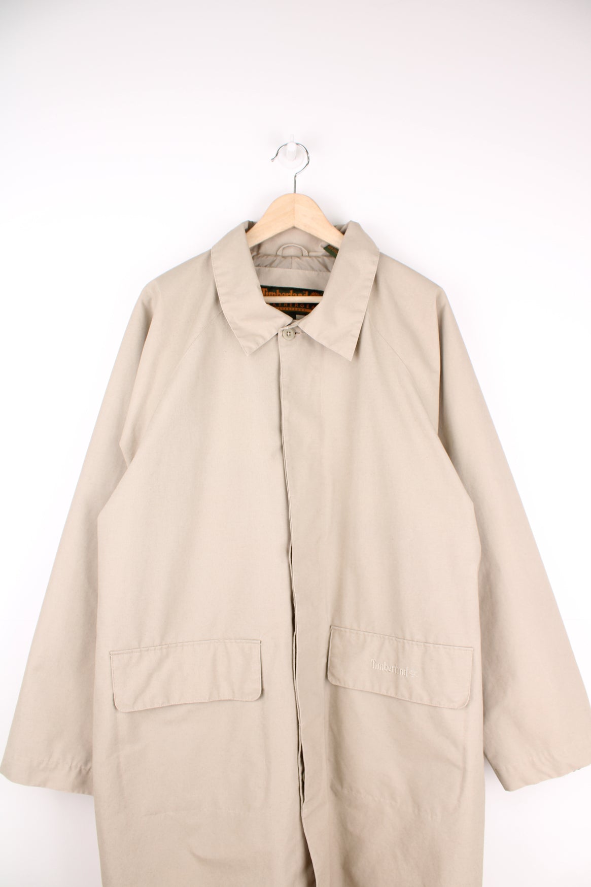 Timberland outdoor button up mac coat in tan, features embroidered spell-out logo on the pocket 