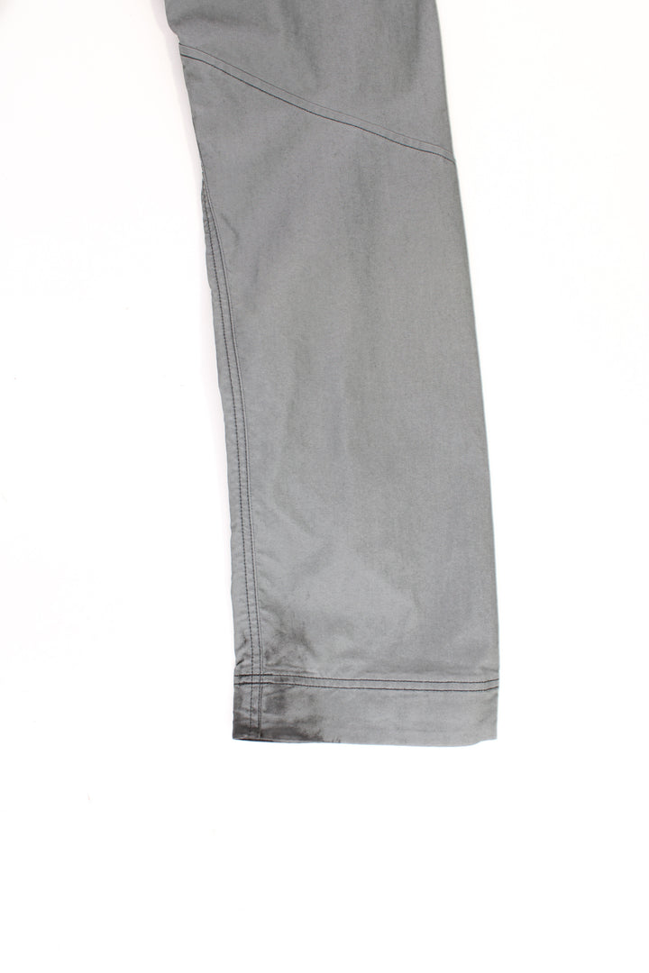 Arcteryx grey slim leg tech trousers with multiple pockets and reflective accents 