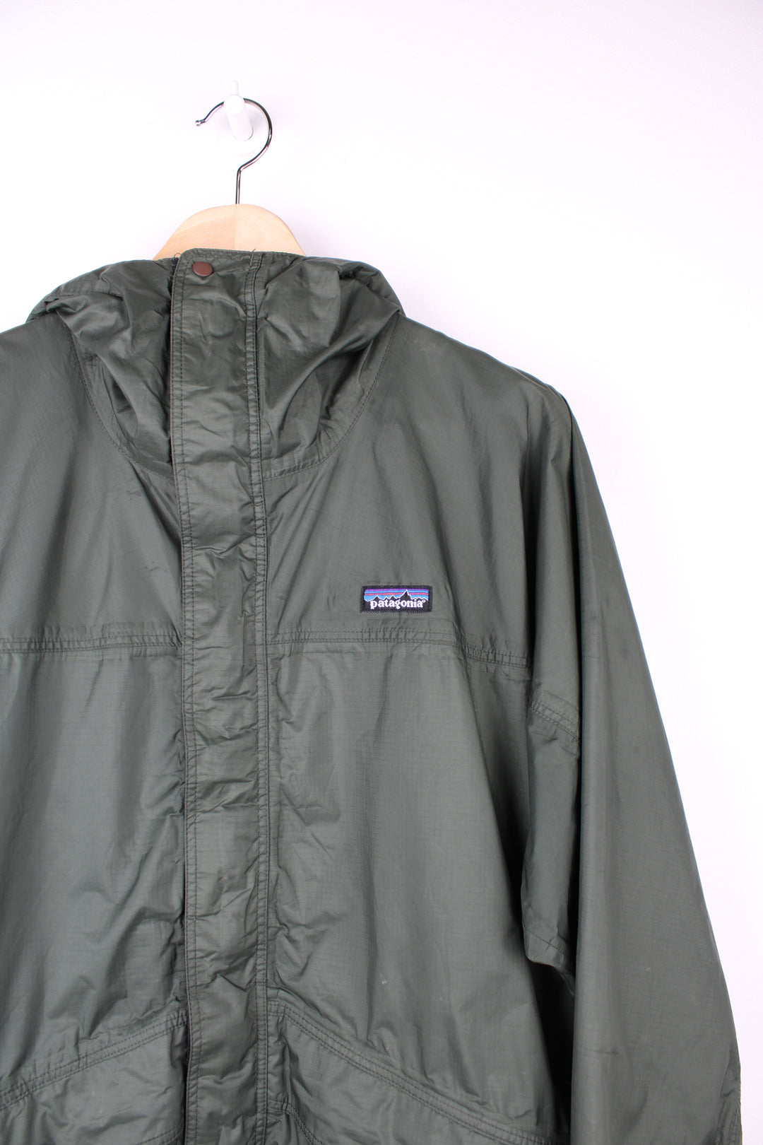 Patagonia Waterproof Jacket in a green colourway, zip up, hooded, adjustable cuffs and has the logo embroidered on the front.