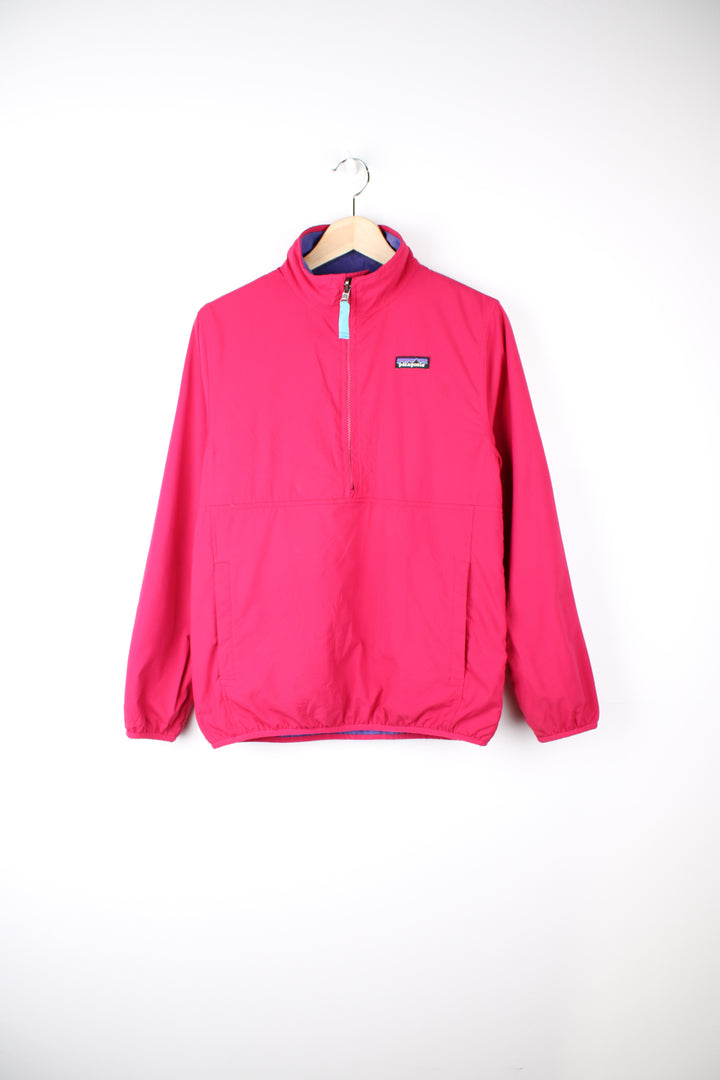 Patagonia Reversible Fleece in either a purple or pink colourway with a fleece or shell option, half zip, pockets and has the logo embroidered on the front.