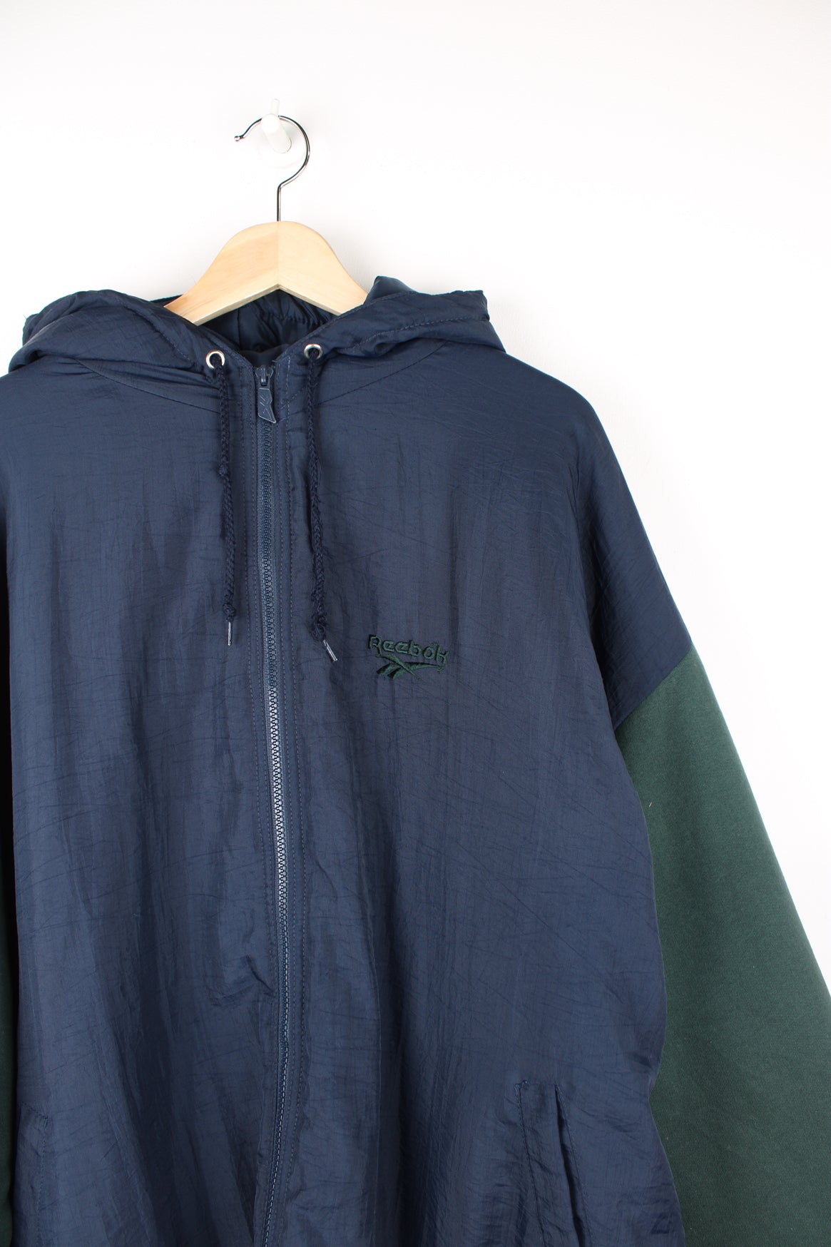 Vintage Reebok zip through hooded jacket in green and blue, features embroidered logo on the chest and back and cotton sleeves