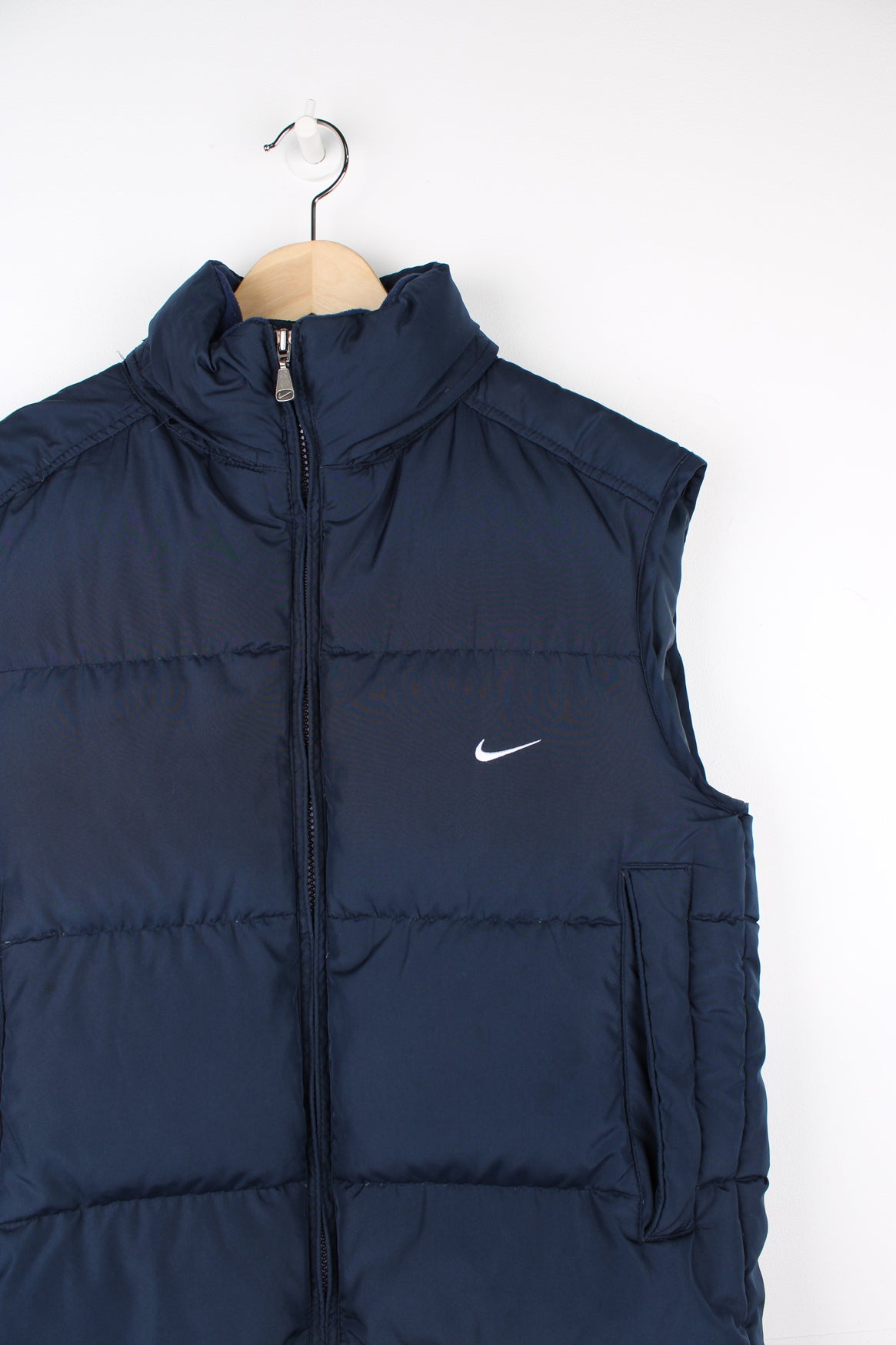 2000s navy blue Nike zip through puffer gilet, with swoosh embroidered logo on the front and foldaway hood