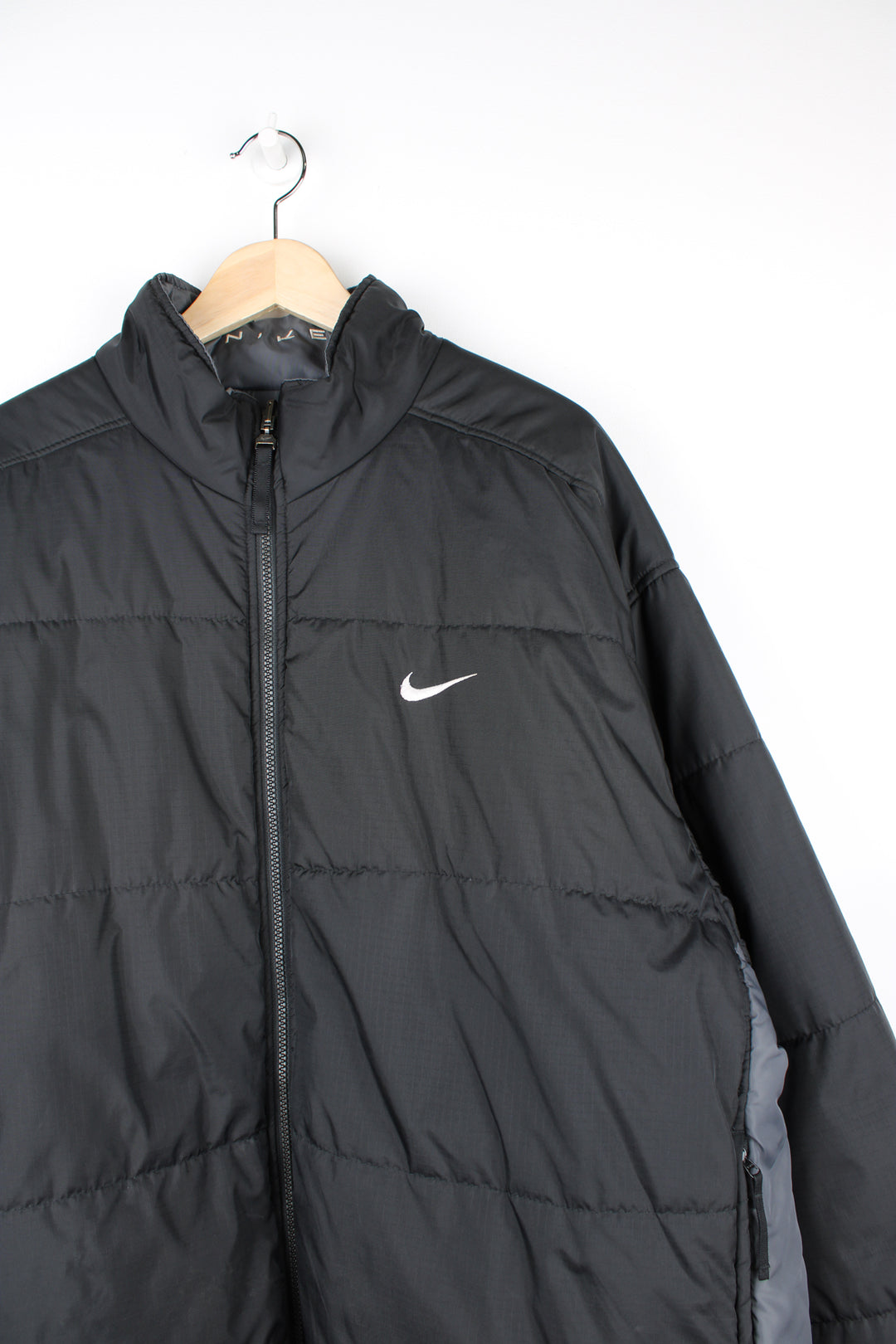 Vintage 2000's reversible Nike puffer jacket in black and grey, features embroidered logos on the chest