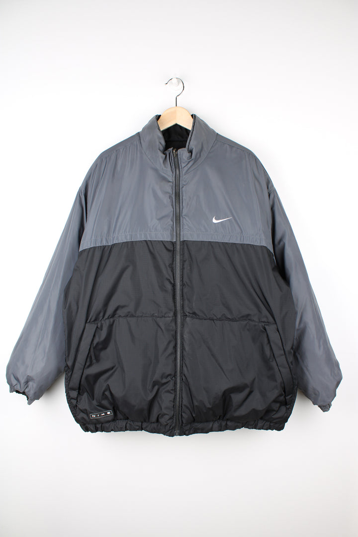 Vintage 2000's reversible Nike puffer jacket in black and grey, features embroidered logos on the chest