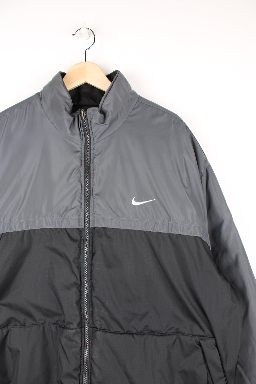 Vintage 2000's reversible Nike puffer jacket in black and grey, features embroidered logos on the chest