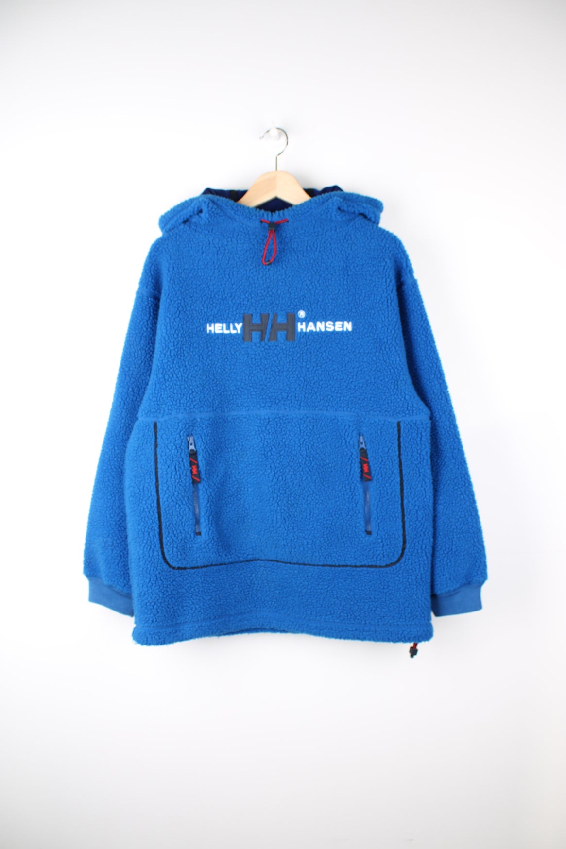 Helly Hansen Pullover Hoodie Fleece in a blue colourway, adjustable hood, big pouch pocket, and has embroidered spell out logo across the front.