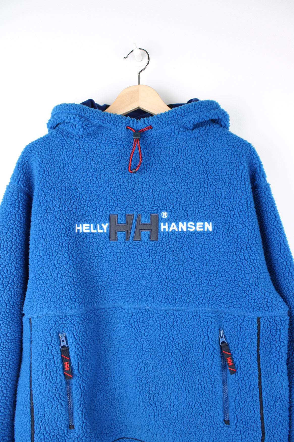 Helly Hansen Pullover Hoodie Fleece in a blue colourway, adjustable hood, big pouch pocket, and has embroidered spell out logo across the front.