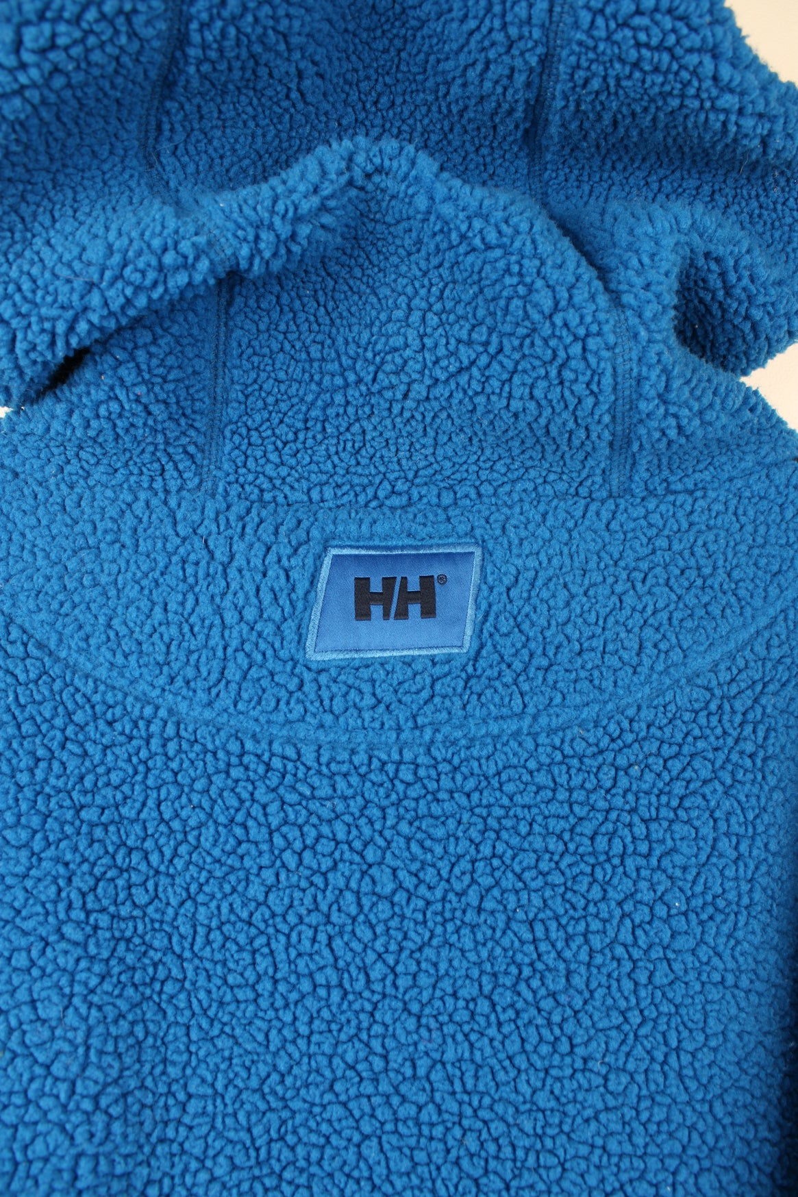 Helly Hansen Pullover Hoodie Fleece in a blue colourway, adjustable hood, big pouch pocket, and has embroidered spell out logo across the front.