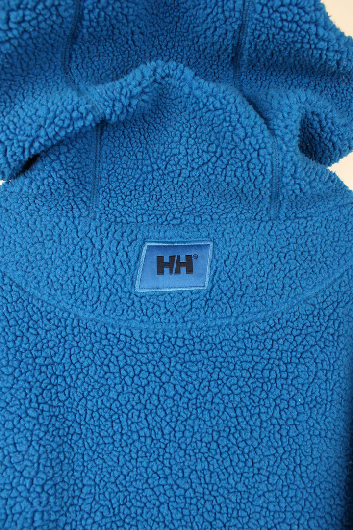 Helly Hansen Pullover Hoodie Fleece in a blue colourway, adjustable hood, big pouch pocket, and has embroidered spell out logo across the front.