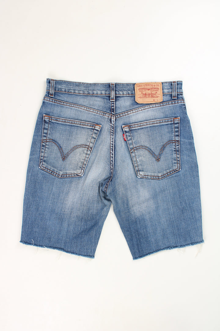 Levi's 525 blue denim jorts with embroidered details on the back pockets and frayed legs