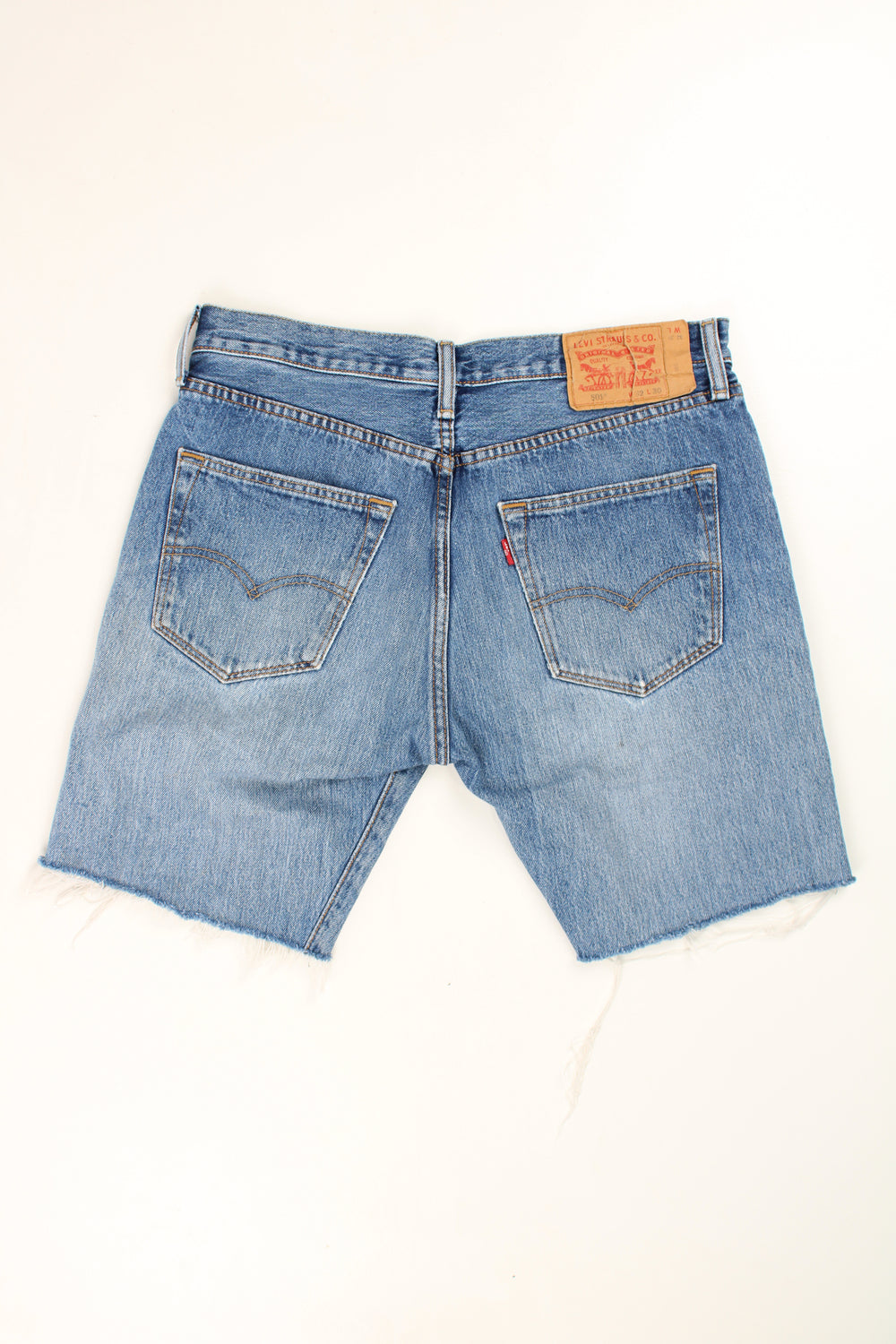 Levi's 501 blue distressed denim jorts with embroidered details on the back pockets and frayed legs