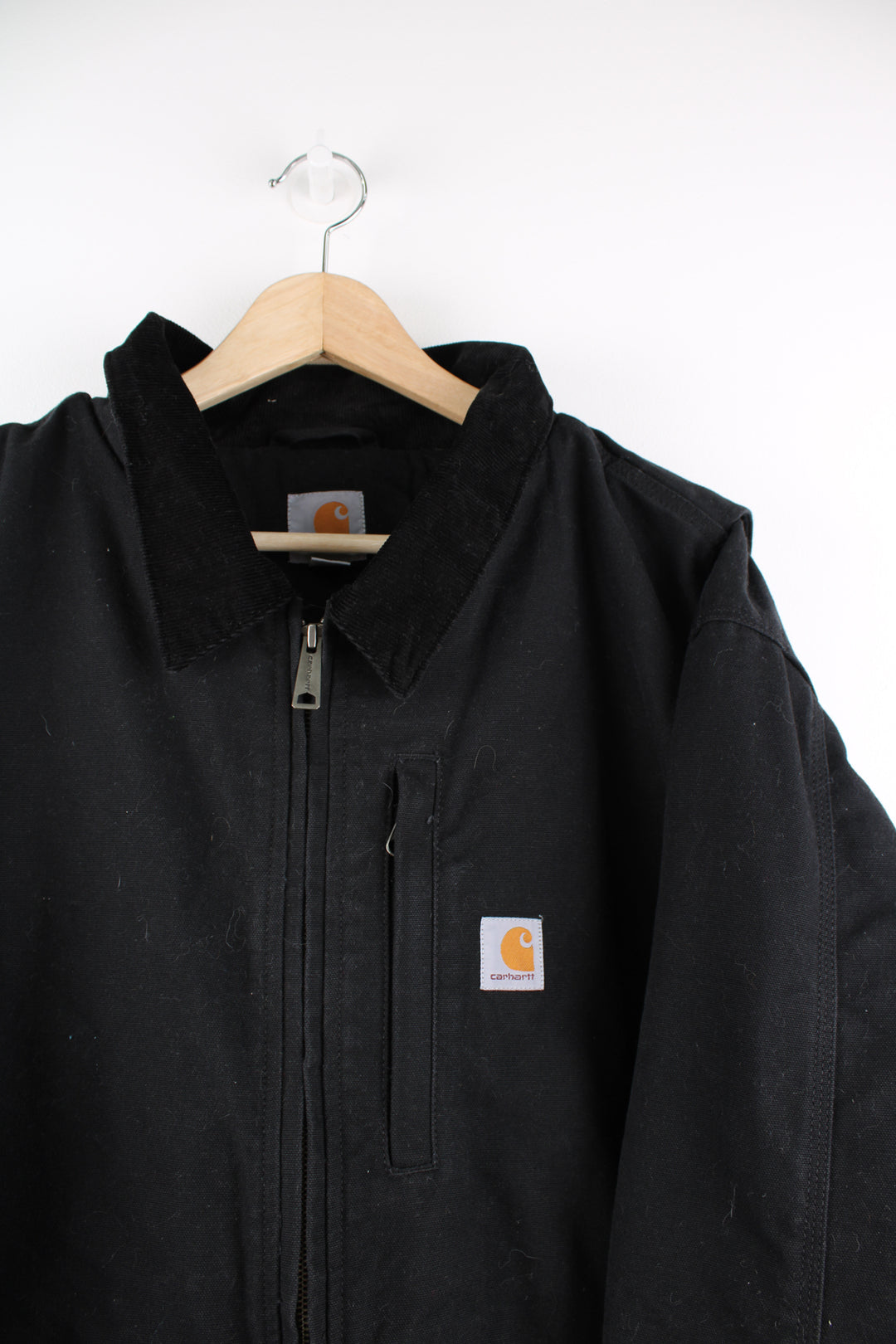 Carhartt Detroit Jacket in a black colourway with a corduroy collar, zip up, multiple pockets, thermal lining, and has the logo embroidered on the front.