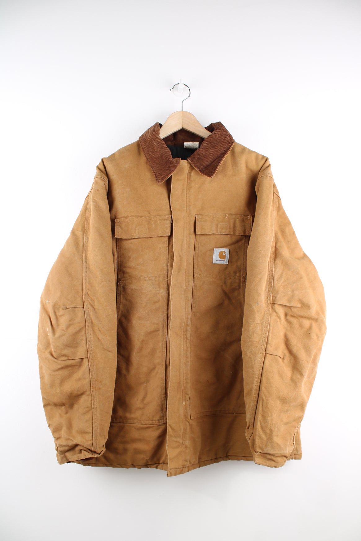 Carhartt Arctic Jacket in a tanned colourway with a brown corduroy collar, zip up, multiple pockets, and has the logo embroidered on the front.