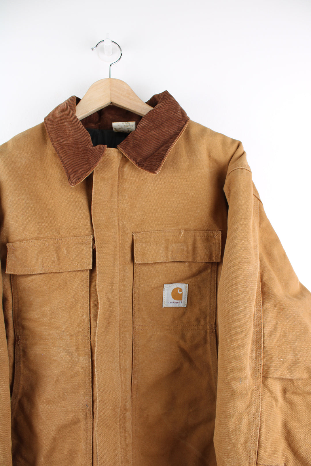 Carhartt Arctic Jacket in a tanned colourway with a brown corduroy collar, zip up, multiple pockets, and has the logo embroidered on the front.