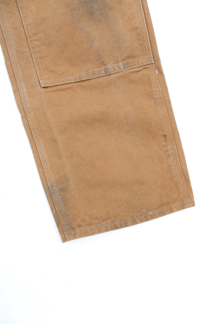 Carhartt double knee carpenter jeans in tan with multiple pockets and signature logo on the back pocket