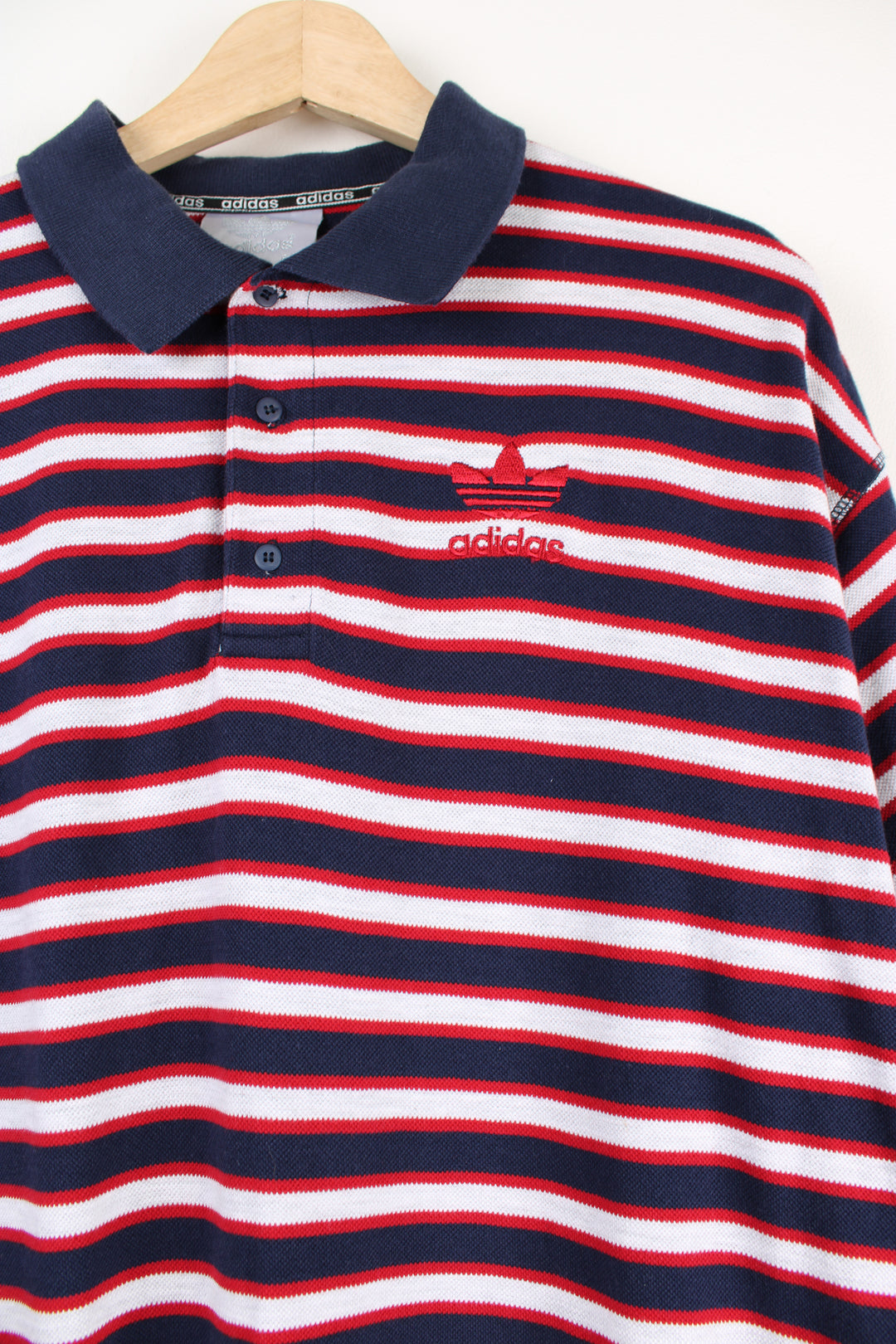 Vintage Adidas blue, red and grey striped polo shirt with embroidered Adidas logo.