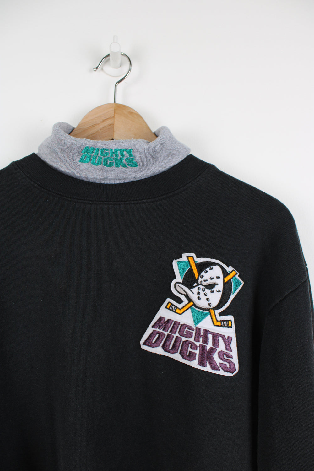 Vintage early 90's Anaheim Mighty Ducks black roll neck sweatshirt, made in the USA by Majestic. Features embroidered badge on the chest and spell-out logo on the neck.