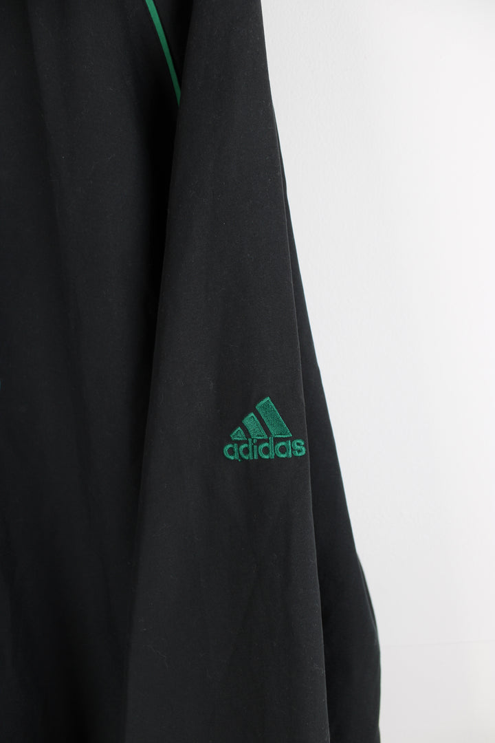 Boston Celtics all black nylon training top/pull over, by Adidas. Features embroidered spell-out logo across the chest, pockets and drawstring waist