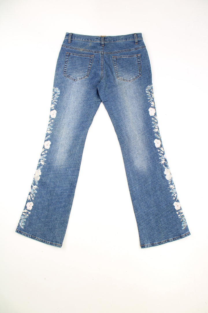 Tenghong Y2K Floral Flared Jeans in a blue colourway, low rise, multiple pockets and has floral patterns going down the side of the legs embroidered with beads.