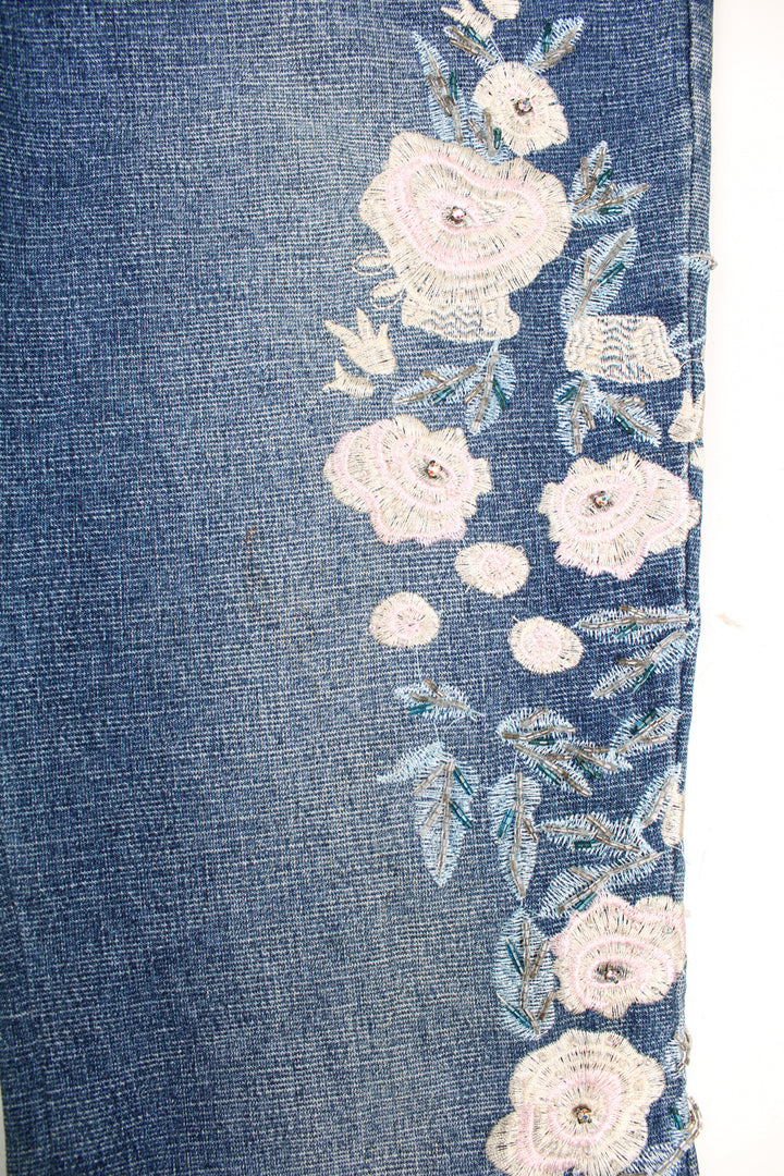 Tenghong Y2K Floral Flared Jeans in a blue colourway, low rise, multiple pockets and has floral patterns going down the side of the legs embroidered with beads.