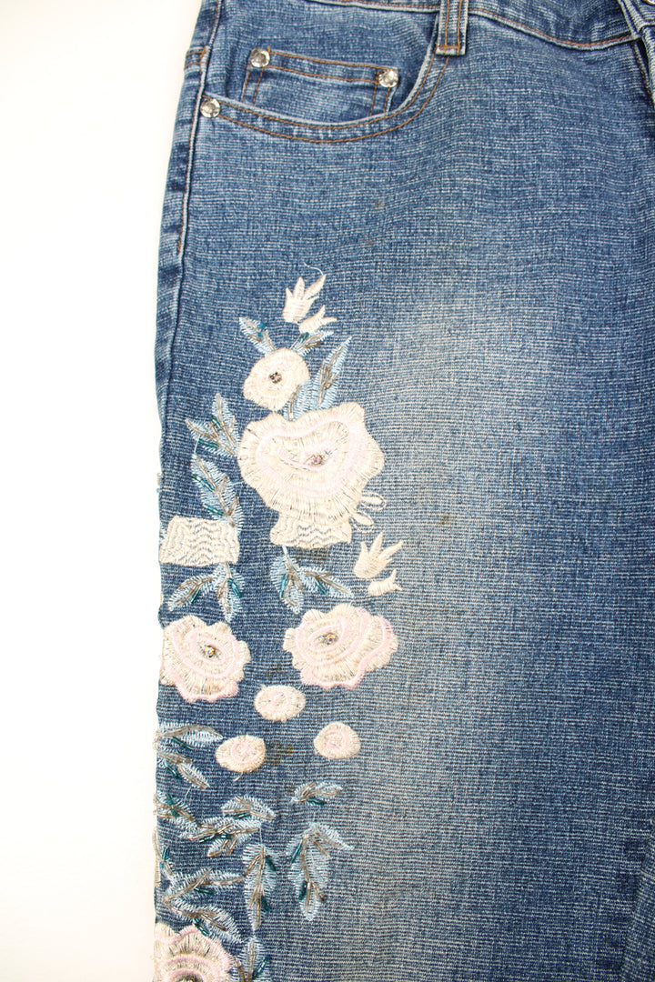 Tenghong Y2K Floral Flared Jeans in a blue colourway, low rise, multiple pockets and has floral patterns going down the side of the legs embroidered with beads.