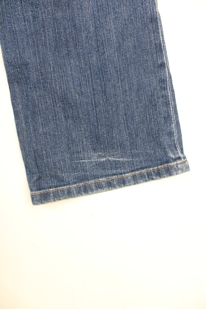 Y2K Morgan Jeans in a blue colourway, low rise, multiple pockets, and has the spell out logo embroidered on both back pockets.