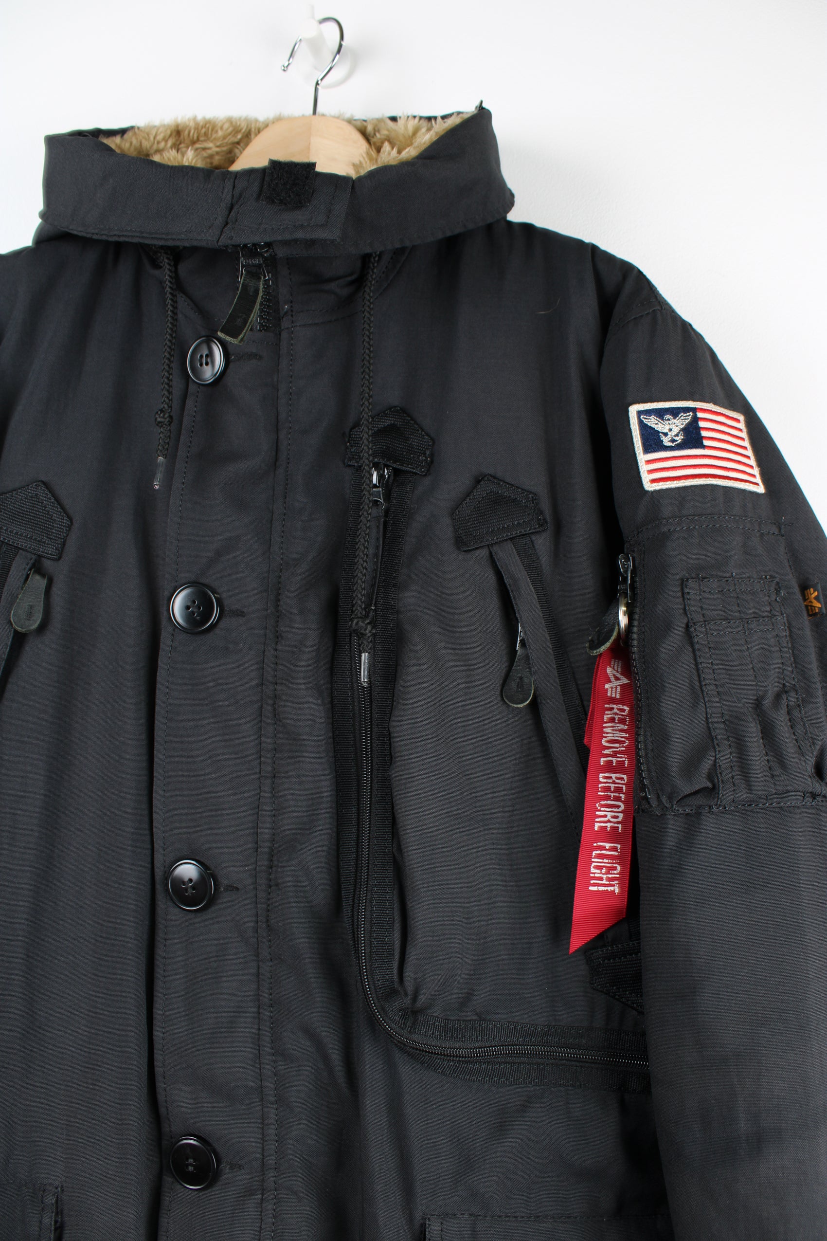 Vintage Alpha Industries black parka coat, features multiple pockets, faux fur lined hood and embroidered badge on the shoulder