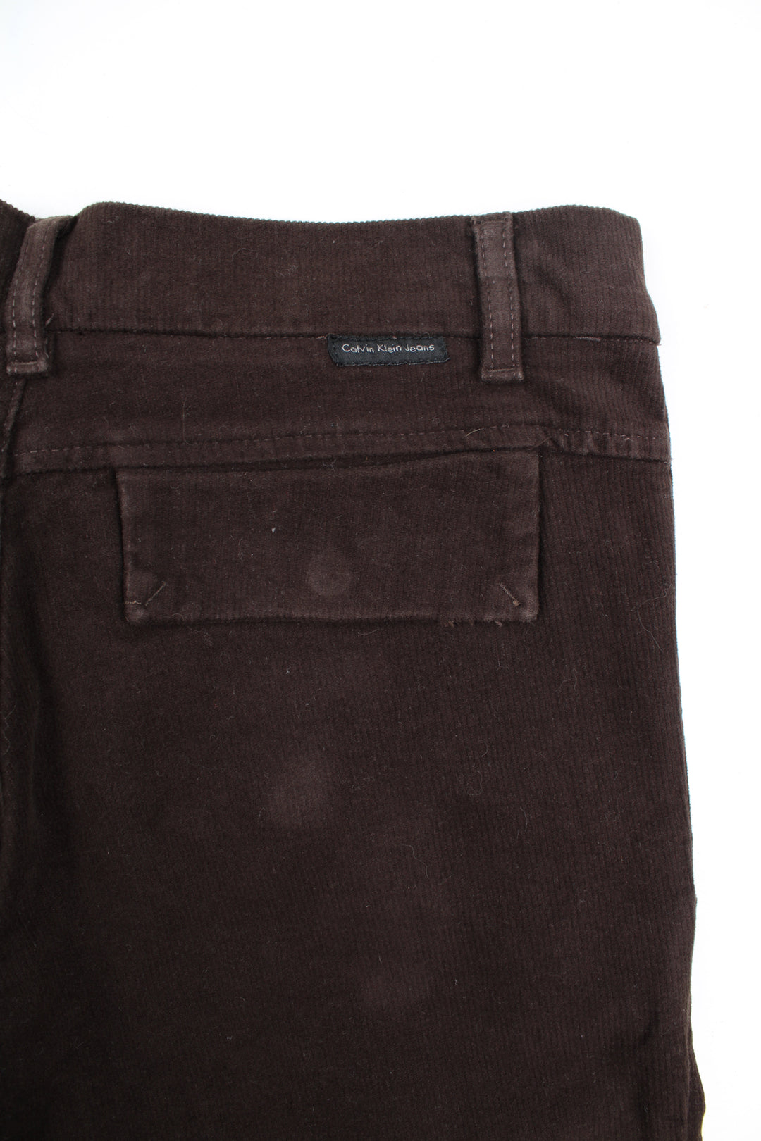 Calvin Klein Flared Corduroy Trousers in a brown colourway, low rise, side pockets, adjustable waist, and has the logo embroidered on the back.