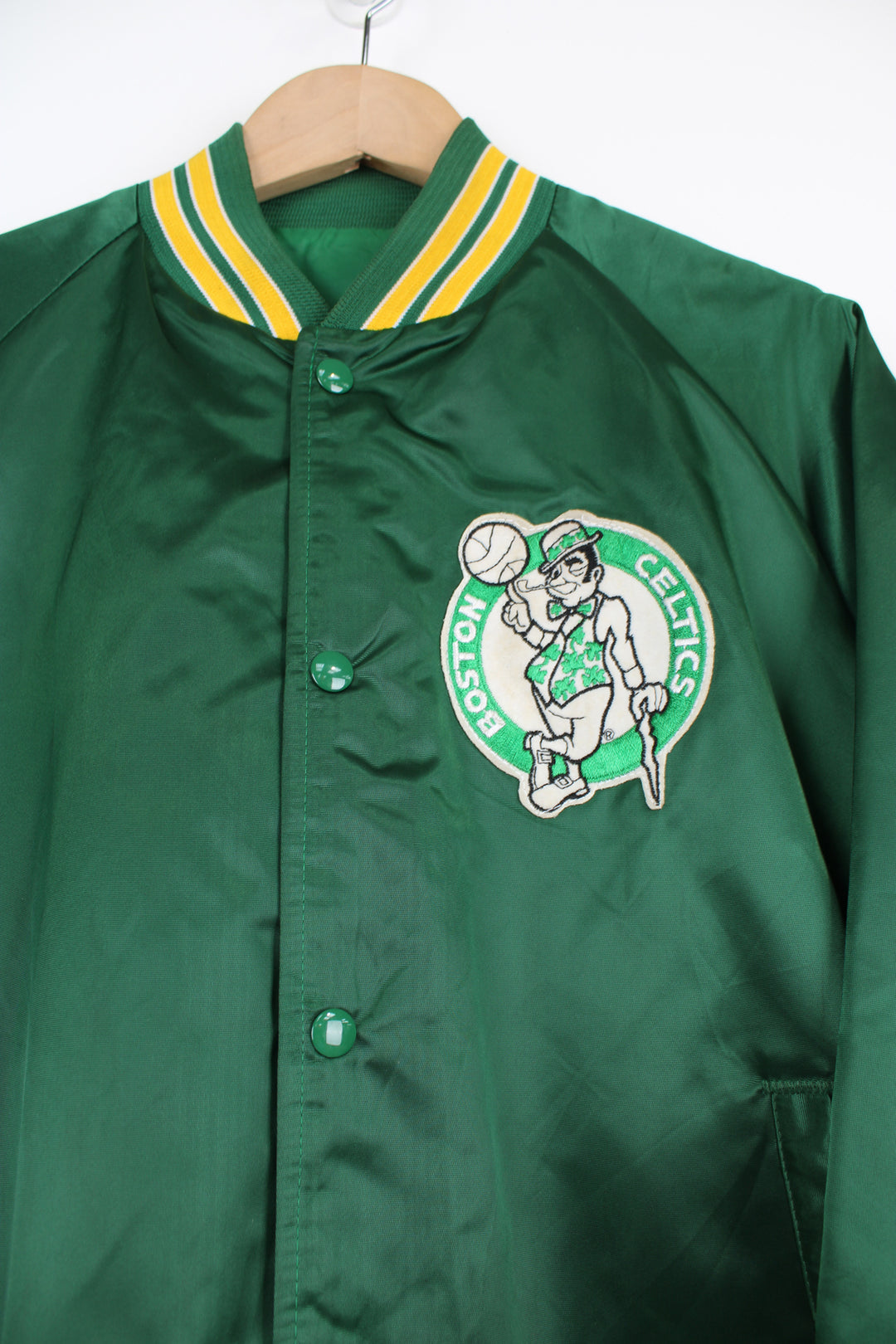 Boston Celtics, NBA Chalk Line Varsity Jacket in a green, white and yellow team colourway, satin material, button up, and has the logo embroidered on the chest.