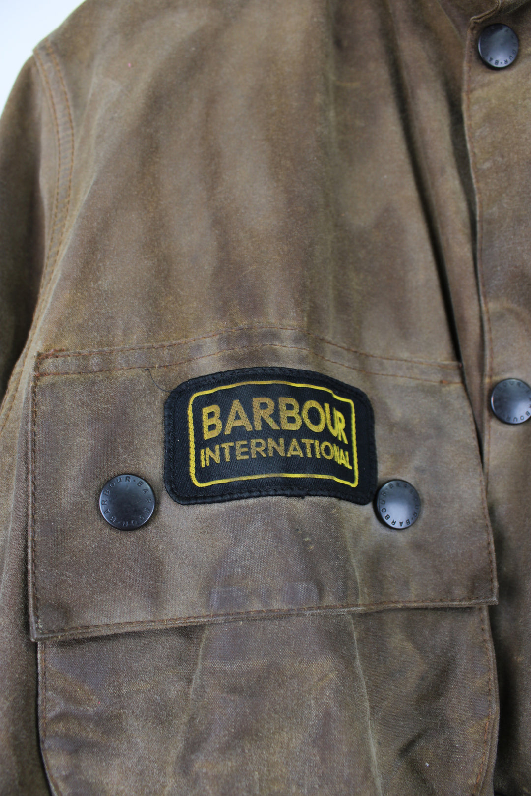 Barbour International A10 motorcycle style wax jacket in khaki green/brown features multiple pockets and belt