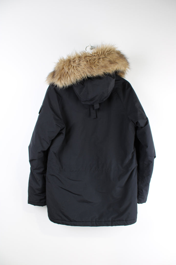 Vintage Carhartt black parka jacket with quilted lining, fur hood and multiple pockets.